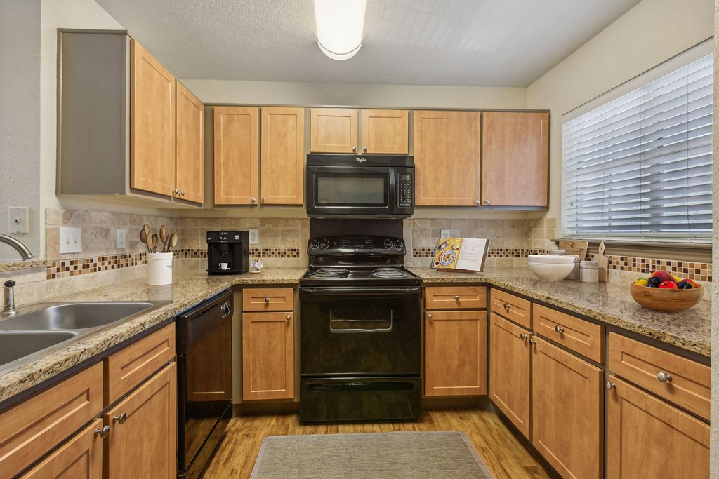 a kitchen with black appliances and wooden cabinets